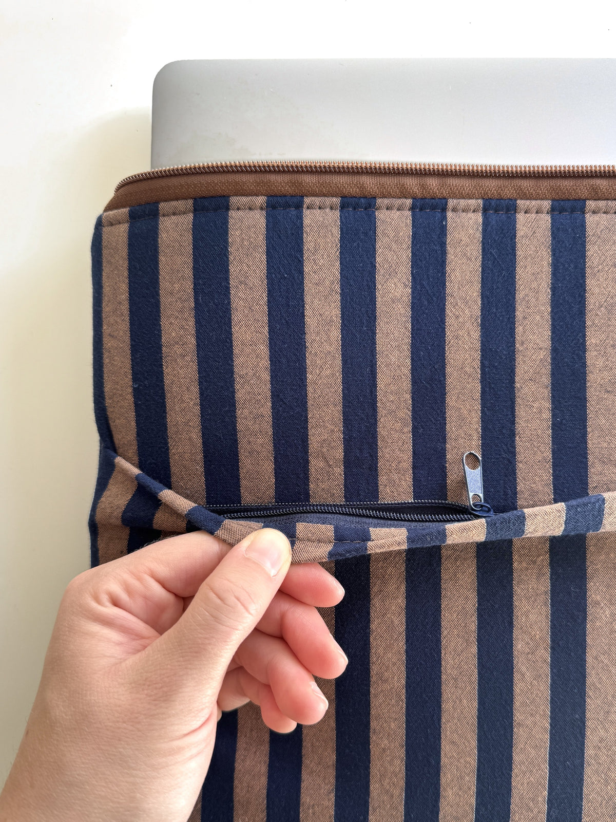 Außenfach mit Reißverschluss an der gestreiften Laptoptasche